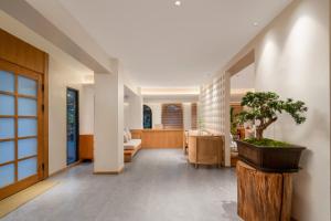 a hallway with a potted tree in a pot at Chongqing Xiannv Mount Peach Blossom Spring Homest in Wulong