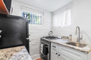 a kitchen with a black refrigerator and a sink at Sojourn Charming Lower Level Studio - Capitol Hill in Washington, D.C. +8 photos