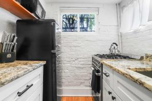 a kitchen with a black refrigerator and a stove at Sojourn Charming Lower Level Studio - Capitol Hill in Washington, D.C.
