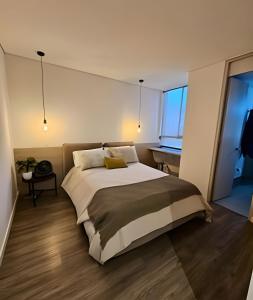 een slaapkamer met een groot bed en een bureau bij Parma 2305 - Elegance in the Urban Heart / Poblado in El Poblado