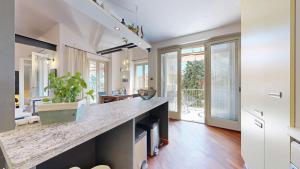 a kitchen with a large counter and a living room at Residenza Ticino in Verbania