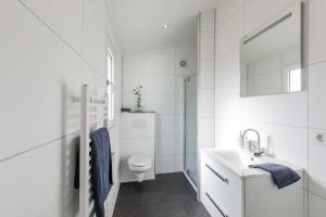 a white bathroom with a toilet and a sink at TopParken – Parc IJsselhoeve in IJssellaan