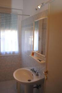 ein Bad mit einem Waschbecken und einem Spiegel in der Unterkunft Hotel Casa Diomira in Lido di Camaiore