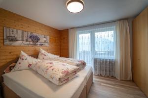 a bedroom with a bed and a large window at Gästehaus Höck in Tschagguns