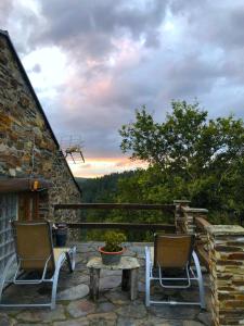 2 sillas y una mesa en un patio con vistas en 39A01 La Casita Olga Casa en plena naturaleza, en Arrojo