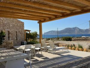 a patio with chairs and a table with a view of the ocean at Sohoro Villas in Koufonisia