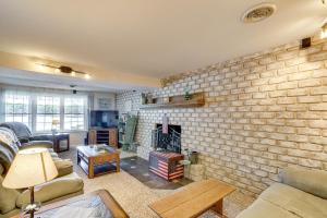 a living room with a brick wall with a fireplace at Lakefront and Dog-Friendly Gem in Gravois Mills in Gravois Mills