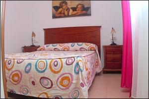 a bedroom with a bed with a colorful comforter at Apartamento Pascual Junquera I in Conil de la Frontera