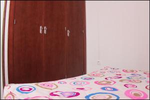 um quarto com uma cama e um armário de madeira em Apartamento Pascual Junquera I em Conil de la Frontera