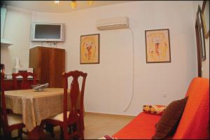 uma sala de jantar com uma mesa e uma televisão na parede em Apartamento Pascual Junquera I em Conil de la Frontera