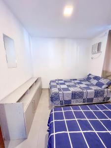 two beds in a white room with blue sheets at Barra de Jacuipe Village T in Camaçari +12 photos