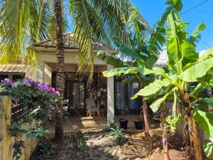 una casa con delle palme davanti di Pointe aux Piments Residence a Pointe-aux-Piments