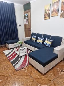 un soggiorno con un divano blu e un tavolo di Cusco House como en casa a Cuzco