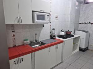 una piccola cucina con lavello e microonde di Cusco House como en casa a Cuzco