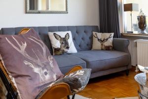 a living room with a blue couch with pillows at Ferienwohnung der Berg ruft in Sankt Andreasberg +20 photos