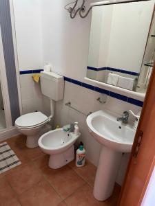 a bathroom with a toilet and a sink and a mirror at Casa Makari in Macari