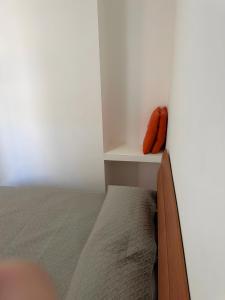 a bedroom with a bed and a orange pillow on a shelf at Casa Makari in Macari +10 photos