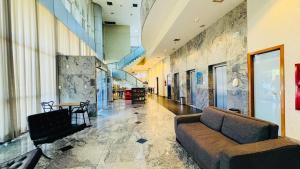 a lobby with a couch and a table in a building at Quarto Mobiliado no Hotel Go Inn Taguatinga com Wi-Fi, Ar Condicionado e Estacionamento Grátis in Brasília