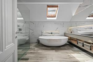 a bathroom with a large tub and two sinks at Luxurious Bowdon Mansion by City SuperHost in Bowdon