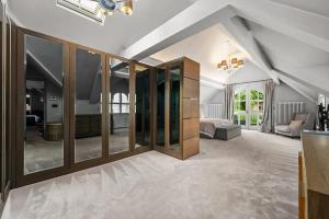 a large room with glass doors and a living room at Luxurious Bowdon Mansion by City SuperHost in Bowdon