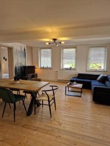 a living room with a table and a couch at 3 Zimmer Ferienwohnung Harter Brocken in Sankt Andreasberg