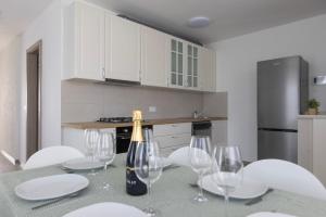 a kitchen with a table with wine glasses on it at Villa Andrea Apartments - Ljubljana in Ljubljana +51 photos