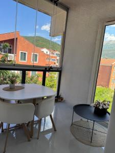 a dining room with a table and chairs and a large window at Central Prestige Apartment in Budva