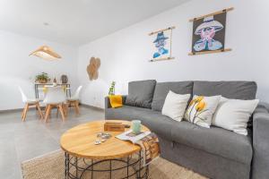 a living room with a gray couch and a table at El Cuarto De Moza in Tinajo