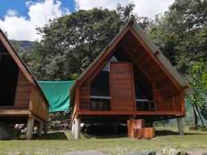 a small wooden house with a pitched roof at INCA COFFEE Lodge Lucmabamba in Sahuayacu
