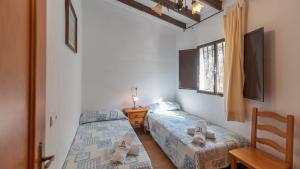 two twin beds in a room with a window at Casa Esperanza Sedella by Ruralidays in Sedella +20 photos
