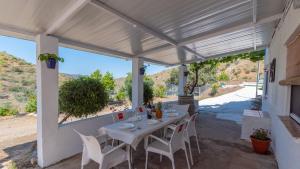 a white table and chairs under a pergola at Casa Esperanza Sedella by Ruralidays in Sedella