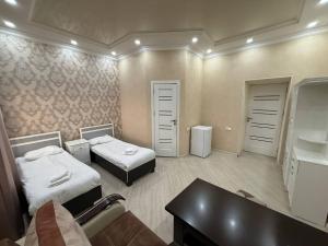 久姆里Olympic Hotel Gyumri的一间医院间,配有两张床和一张桌子