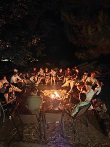 a group of people sitting around a fire at night at High Hostel in Budva