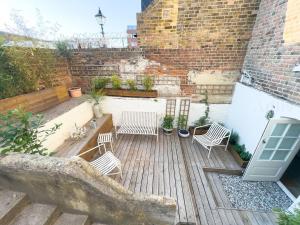 eine Terrasse mit zwei weißen Stühlen auf einer Holzterrasse in der Unterkunft Georgian Luxury Margate Tnhouse Sleeps 11 By Adliv in Margate