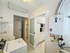 a white bathroom with a sink and a stove at Amplo apartamento no coração da Cidade, quadra mar in Piçarras +43 photos