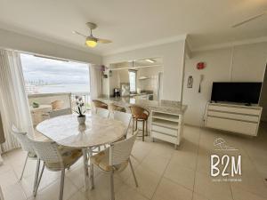 a kitchen and dining room with a table and chairs at Amplo apartamento no coração da Cidade, quadra mar in Piçarras