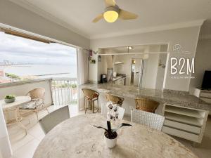a dining room with a table and a view of the ocean at Amplo apartamento no coração da Cidade, quadra mar in Piçarras