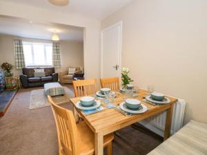 a dining room with a wooden table and chairs at Bryn Hyfryd in Conwy +15 photos