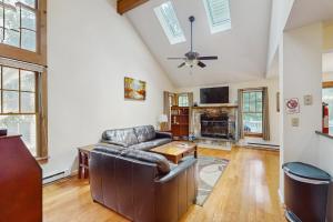 Una sala de estar con un sofá de cuero y un televisor. en Northridge 410, en Tannersville