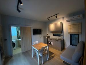a living room with a table and a kitchen at Morgen Resort24h in Ban Don