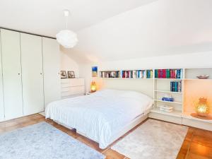 a white bedroom with a bed and bookshelves at Haus Schütz in Grömitz +16 photos