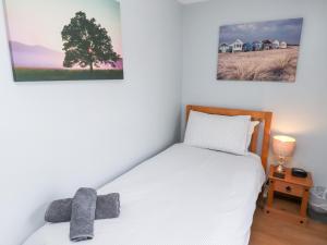 Un dormitorio con una cama y dos cuadros en la pared. en Hasting Dairy, en Seahouses