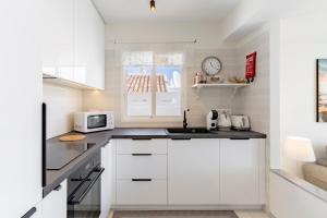 een keuken met witte kasten en een magnetron bij Apartment in Miraflores in Mijas Costa