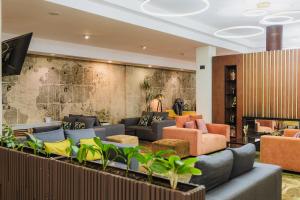 a lobby with couches and chairs and a wall at Comfort Hotel Astana in Astana