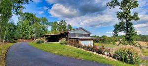 a home with a driveway leading to a house at Southern Comfort Retreat with a private hot tub in Scottsboro