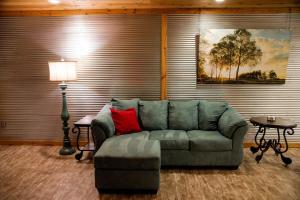 a living room with a green couch and a lamp at Southern Comfort Retreat with a private hot tub in Scottsboro +68 photos