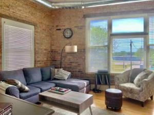 a living room with a blue couch and a brick wall at Romantic Gastro Loft Retreat for Two in Benton Harbor