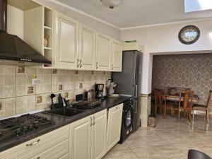 a kitchen with white cabinets and a black refrigerator at Premier House in Târgu Ocna