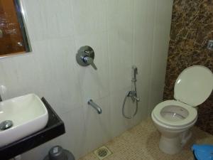 a bathroom with a shower and a toilet and a sink at Hotel Regal Palace in Mumbai