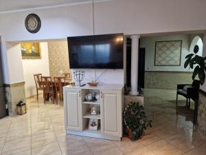 a living room with a flat screen tv on a stand at Premier House in Tîrgu Ocna